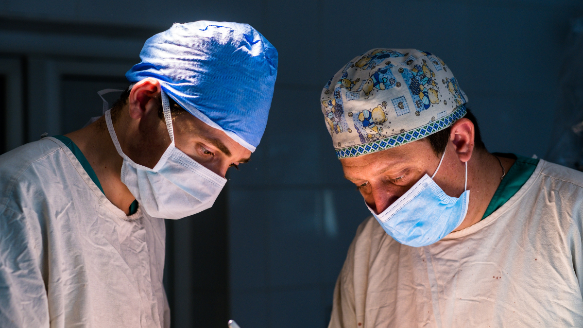 Two surgeons performing a back surgery procedure in an operating room
